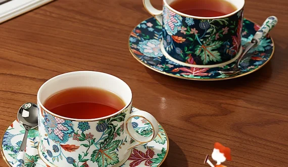 Clarence 6‑piece Coffee Cup and Saucer Set, matching‑spoon styling display of floral coffee cups with coffee on wooden tabletop