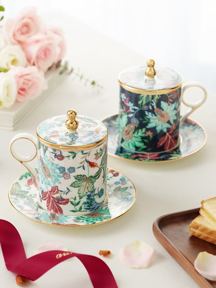 Clarence 3‑piece Cup Lid Set - Pair of Cups (350ml), panoramic display of two‑person dark‑floral gold‑trim lidded mug set with saucers, pink roses and toast on soft‑light white tabletop